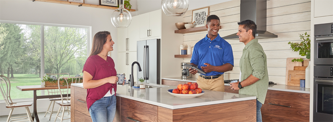 Carrier dealer with homeowners in kitchen